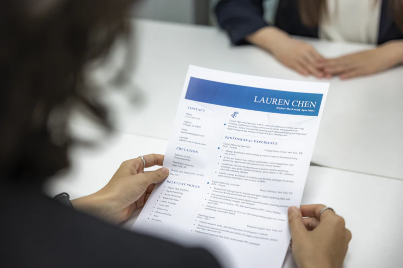 Recruiter reviewing a printed CV at a meeting table