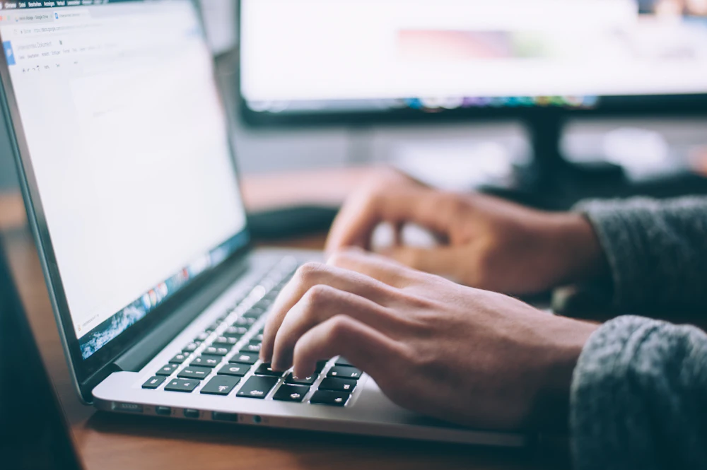 Support administrator working through an email and ticket queue on a laptop